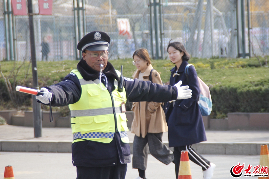 圖2、15日上午11時(shí)41分許，楊秀山在致遠(yuǎn)路上指揮過往的車輛以及下課了的學(xué)生。大膽走、向前走、快點(diǎn)走，這是楊秀說的山上崗工作時(shí)最多的話。.jpg